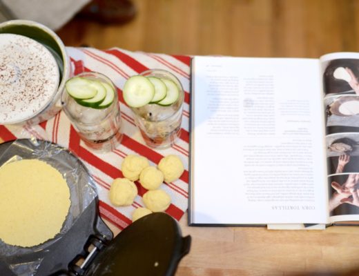 tortilla in a taco press with two glasses garnished with cucumber