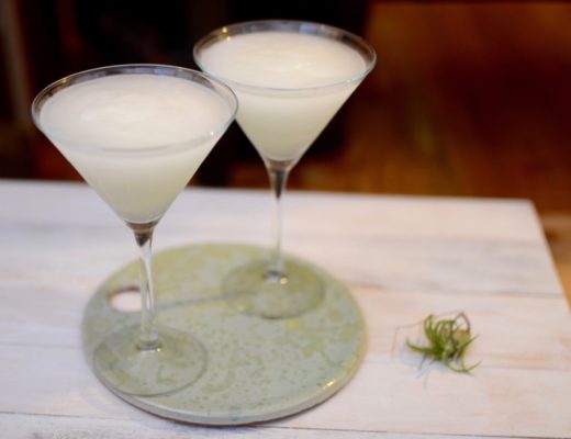 two martini glasses with a white rum cocktail on homemade pottery