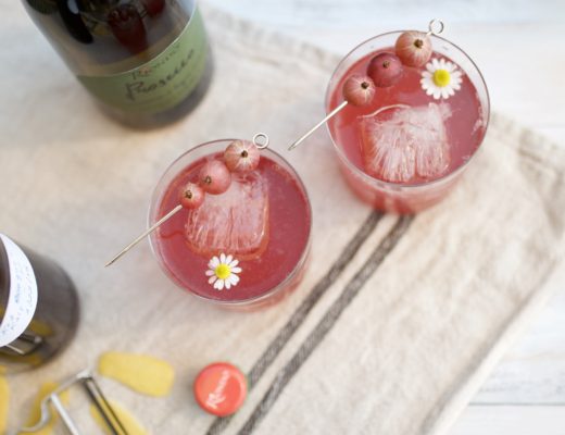 two pink cocktails with gooseberries and chamomile flower