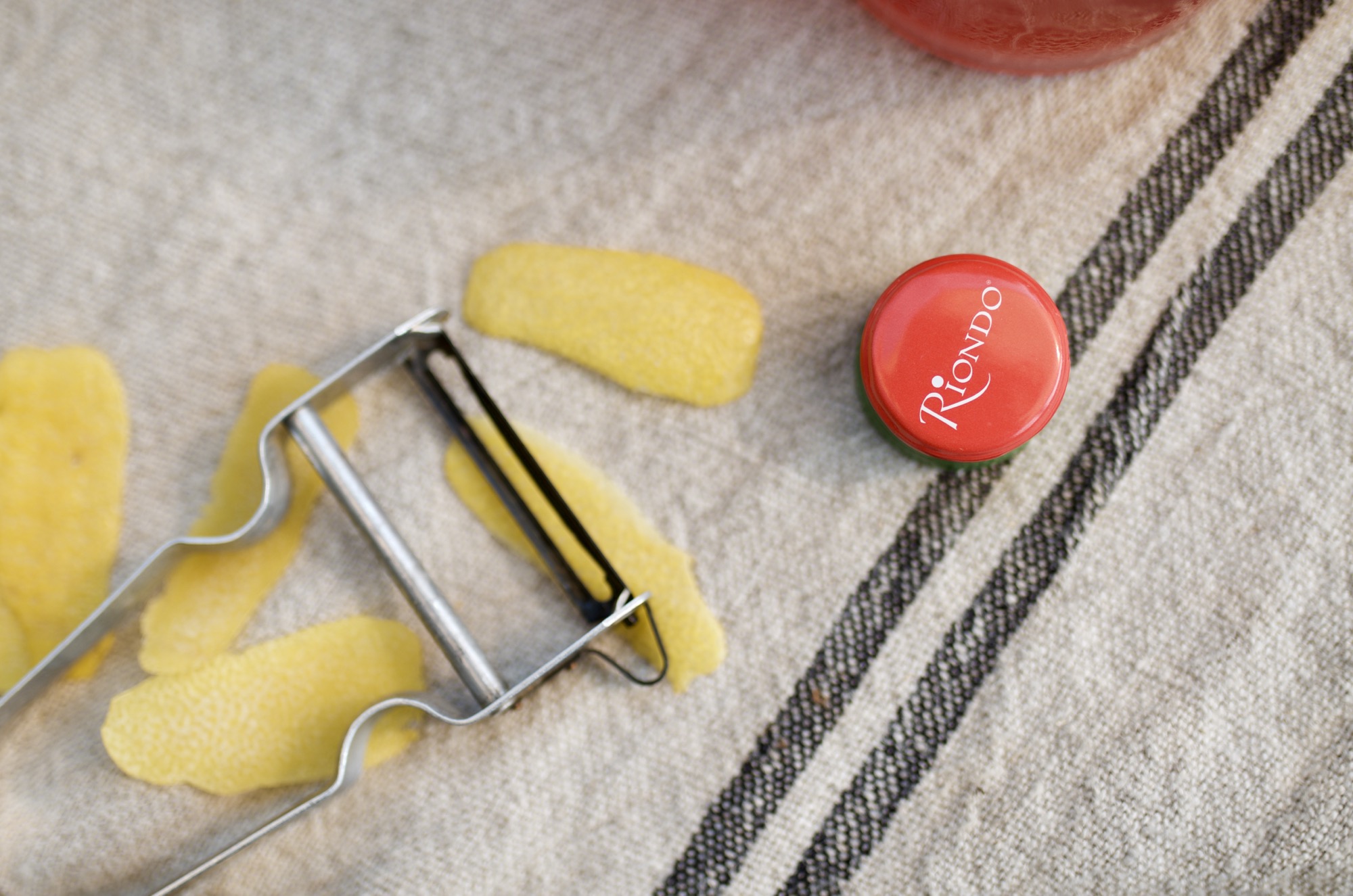 riondo bottle cap and a peeler with lemon garnishes