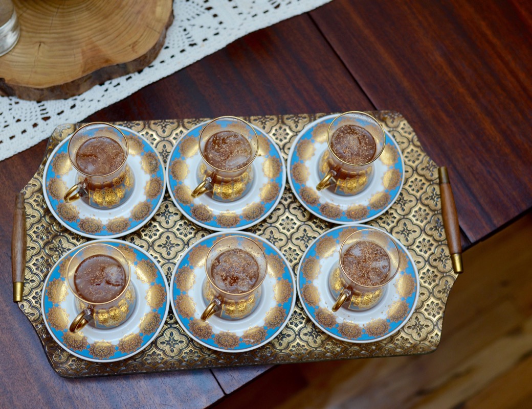 6 Turkish tea cups on a gold tray with a cocktail